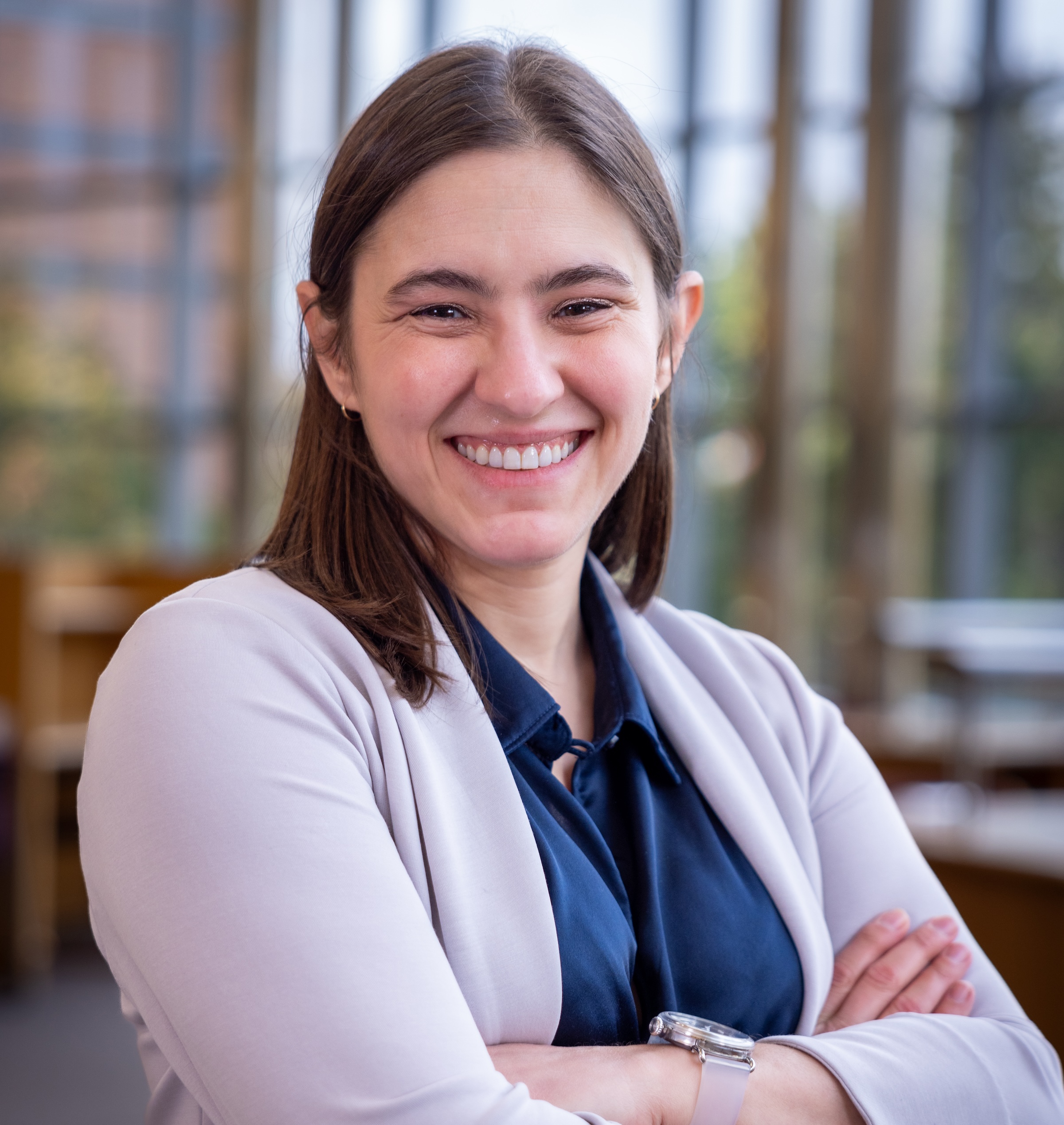 Anne, a white woman with shoulder length brown hair, smiling with arms crossed